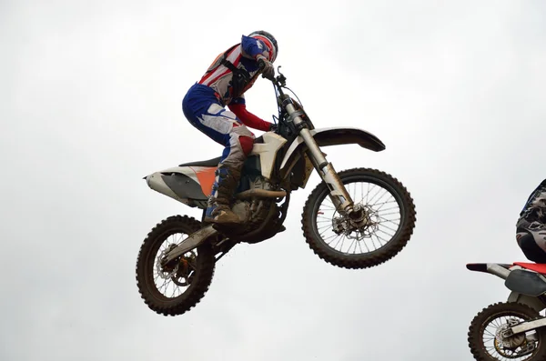 Motocross rider flies through the air turning his head — Stockfoto
