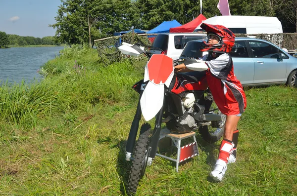 Ragazza in un casco costa circa moto motocross . — Foto Stock