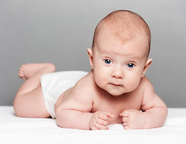 Bebé pequeno bonito sobre cinza — Fotografia de Stock