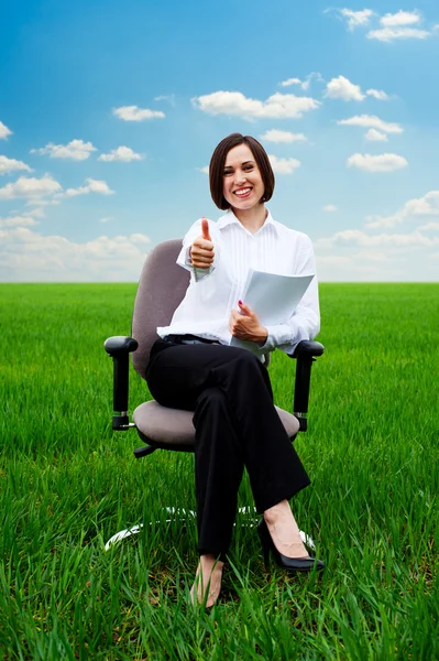 Affärskvinna med dokument som visar tummen upp på fältet — Stockfoto