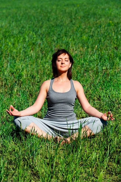 Mujer meditando en el prado verde — Foto de Stock
