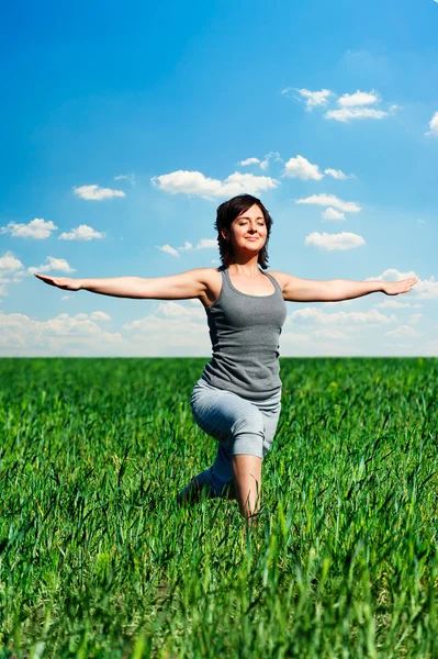 Vrouw op de weide beoefenen van yoga op zonnige dag — Stockfoto