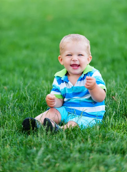 Мальчик играет на зеленой траве — стоковое фото