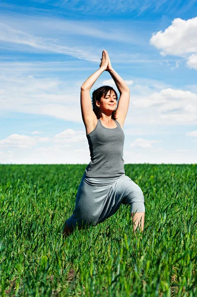 Счастливая женщина медитирует на поле — стоковое фото