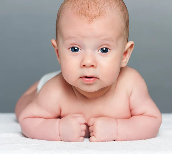 Bonito bebé sobre fondo gris — Foto de Stock