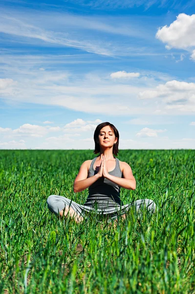 Mulher meditando no prado verde — Fotografia de Stock
