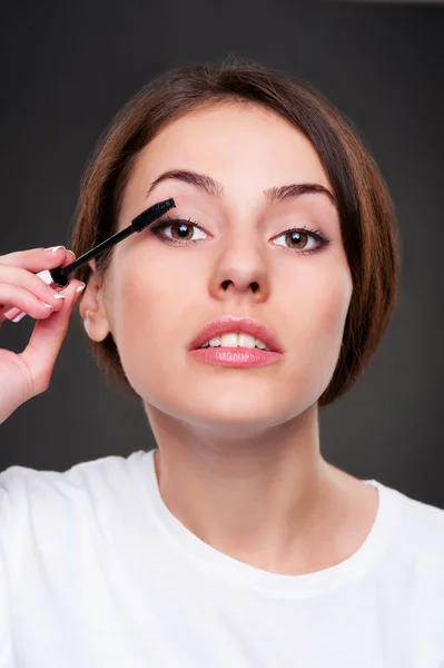 Mulher bonita aplicando maquiagem — Fotografia de Stock