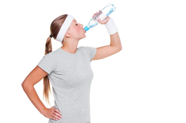 Kobieta w szary t-shirt wody pitnej — Zdjęcie stockowe