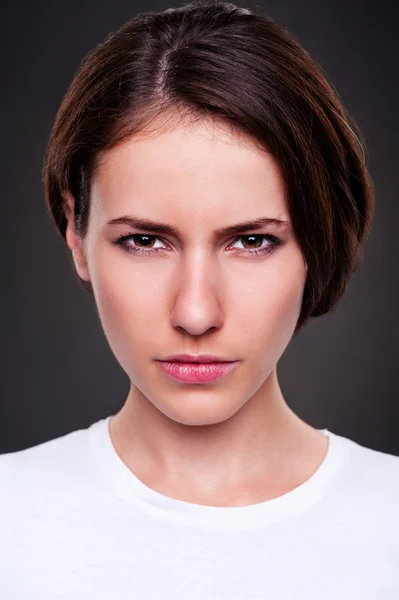 Serious woman over dark background — Stock Photo, Image