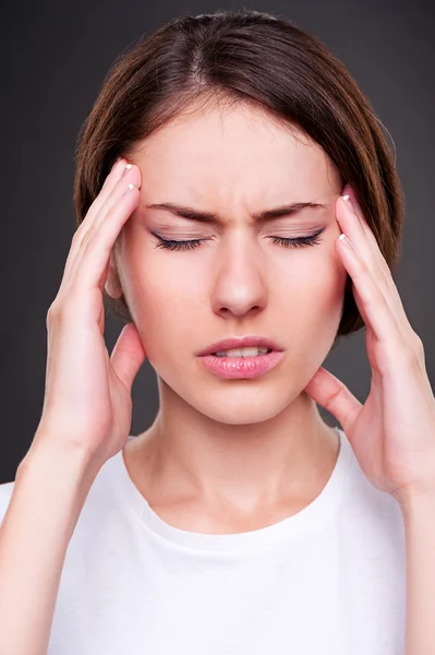 Mujer joven tiene dolor de cabeza — Foto de Stock