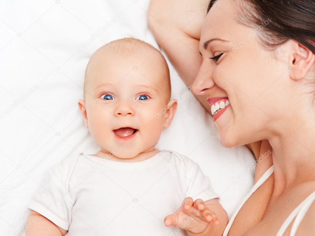 Baby and mother lying in bed