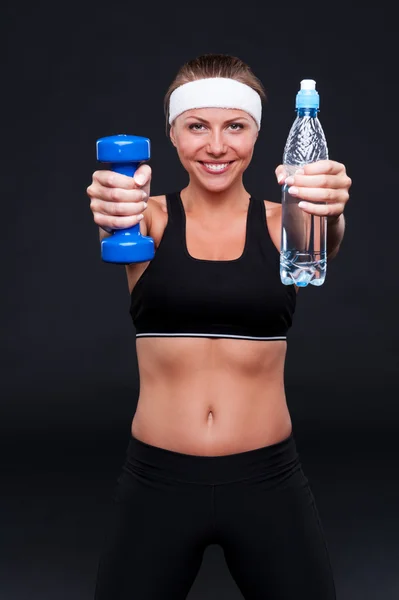 Woman holding bottle of water and weight — Stock Photo, Image