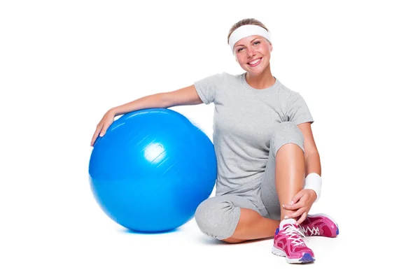 Fitness kvinna sitter nära blå bollen — Stockfoto