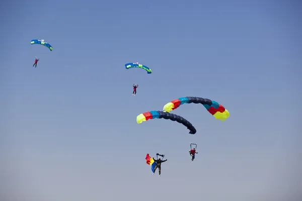 Grupo de pára-quedistas aterrando durante uma demonstração aérea Fotos De Bancos De Imagens Sem Royalties