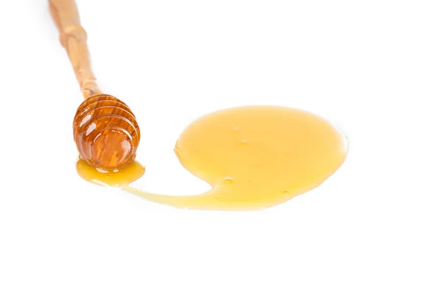 Colher de mel em um fundo branco — Fotografia de Stock