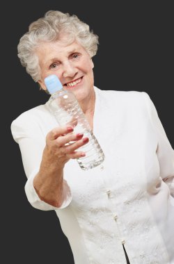 Portrait of healthy senior woman holding a water bottle over bla clipart