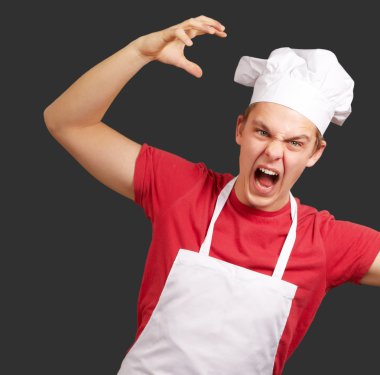 agresif gestur yapıyor önlük giyen genç aşçı adam portresi