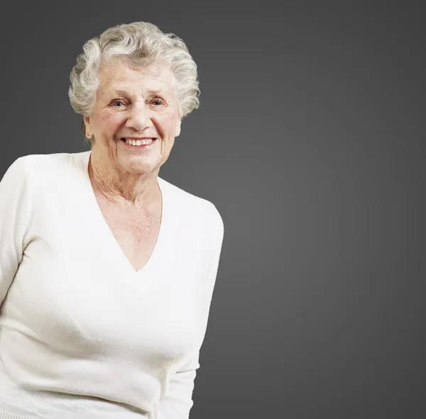 Красива старша жінка посміхається на чорному тлі — стокове фото
