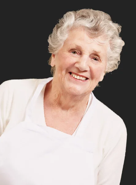 Retrato de cozinheiro mulher sênior contra um fundo preto — Fotografia de Stock