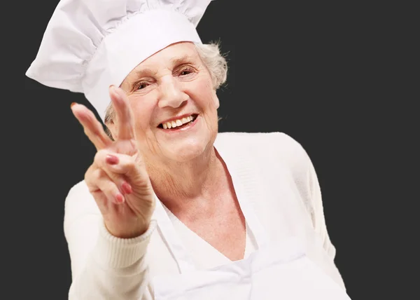 Portret van senior vrouw cook goedkeuring gebaar doen over zwart — Stockfoto