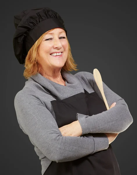 Портрет женщины-повара в фартуке на черном фоне — стоковое фото
