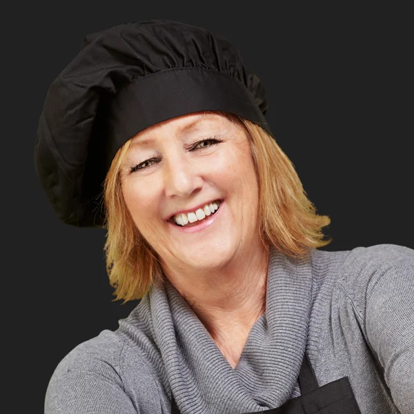 Retrato de mujer cocinera de mediana edad sonriendo sobre negro —  Fotos de Stock