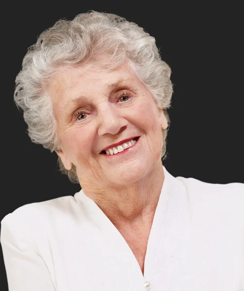 Porträt einer entzückenden Seniorin, die über schwarzem Hintergrund steht — Stockfoto
