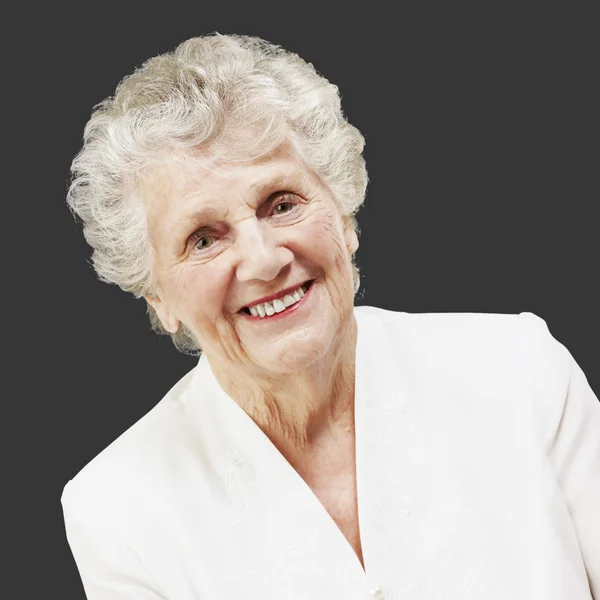 Retrato de una mujer mayor bonita sonriendo contra un fondo negro —  Fotos de Stock