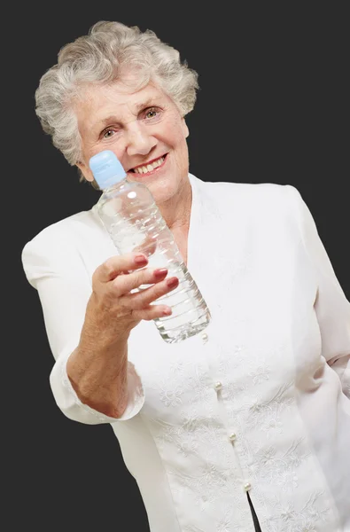 Porträtt av friska äldre kvinna innehar en vattenflaska över bla — Stockfoto