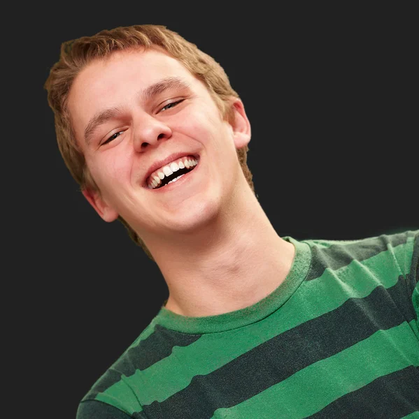 Portrait of young man smiling over black background — Stock Photo, Image