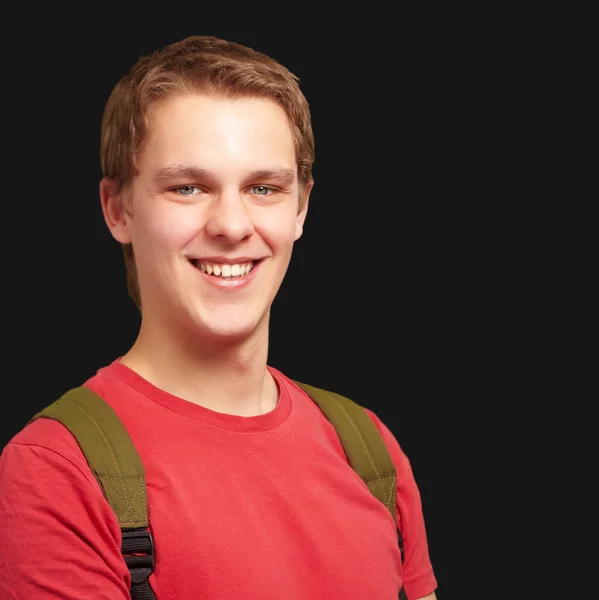 Porträtt av ung student man ler och bär ryggsäck över — Stockfoto