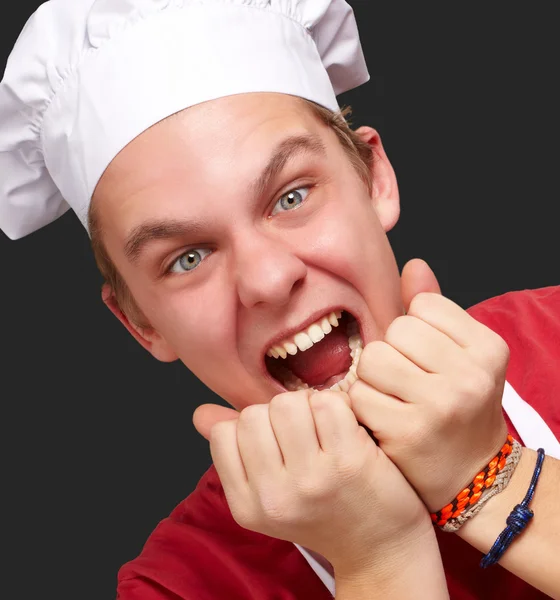 Портрет молодого кухаря, що кричить над чорним тлом — стокове фото
