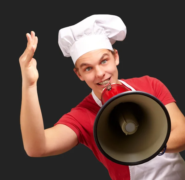 Portrait d'homme cuisinier heureux criant à l'aide de mégaphone sur noir b — Photo