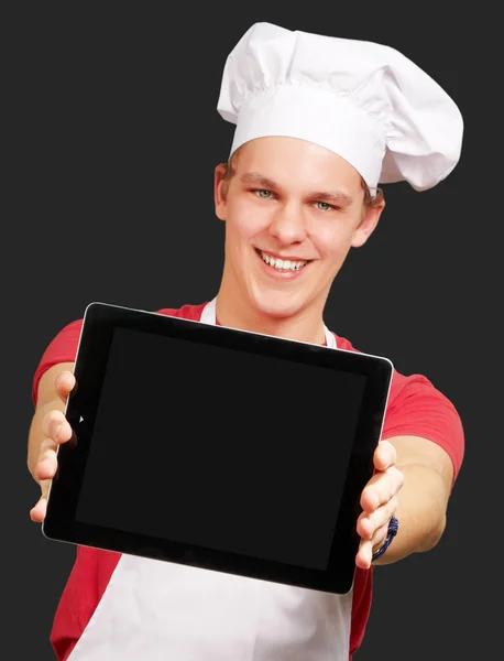 Πορτρέτο του ανθρώπου νέους μάγειρας που δείχνει μια ψηφιακή δισκίο πάνω από μαύρο β — Φωτογραφία Αρχείου