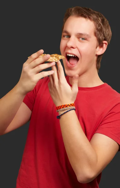 Portré, fiatal ember eszik pizza felett fekete háttér — Stock Fotó