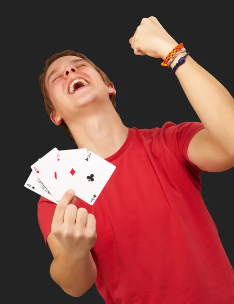 Portrait of young man doing a winner gesture playing poker over — Stock Photo, Image