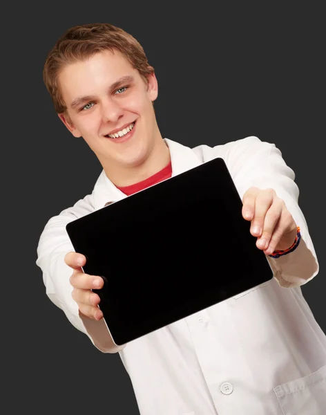 Portrét mladého muže, ukazující digitálním tabletu nad černou poz — Stock fotografie