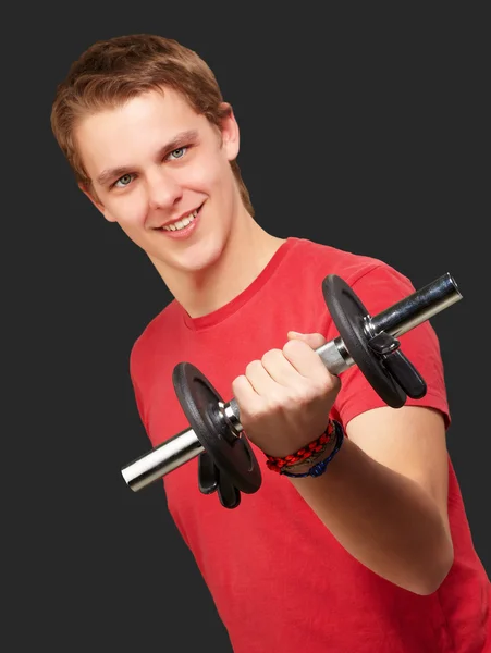 Porträtt av ung man med vikter över svart bakgrund — Stockfoto