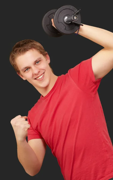 Młody człowiek robi fitness z wagi na czarnym tle — Zdjęcie stockowe
