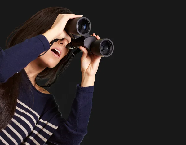 Retrato de menina olhando através de um binóculos sobre preto — Fotografia de Stock