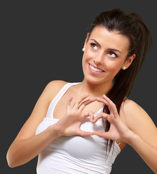 Portret van gezonde meisje gebaren hartsymbool over zwart — Stockfoto