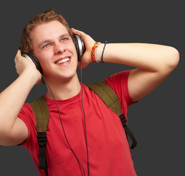 Portrait of cheerful young student listening music with headphon Stock Photo
