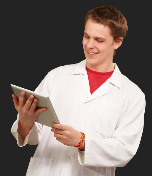 Portrait of young academic holding a digital tablet over black b Stock Photo