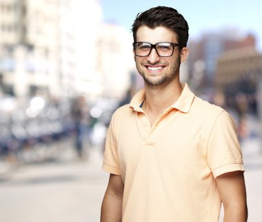 kalabalık bir sokakta gülümseyen güzel ve genç bir adam portresi