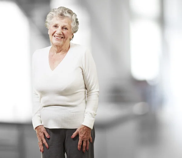 Симпатичная пожилая женщина улыбается, в помещении — стоковое фото
