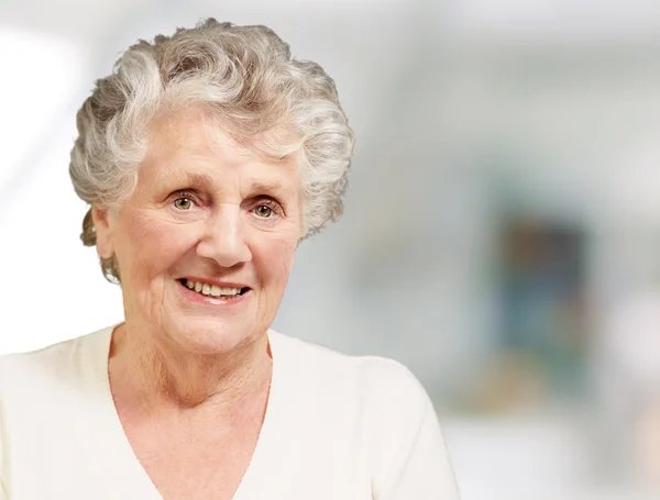 Αρκετά ηλικιωμένη γυναίκα, χαμογελαστά εσωτερική — Φωτογραφία Αρχείου