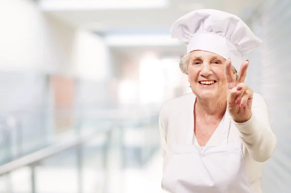 Portret senior kobieta kucharz robi dobry gest w restauracji — Zdjęcie stockowe