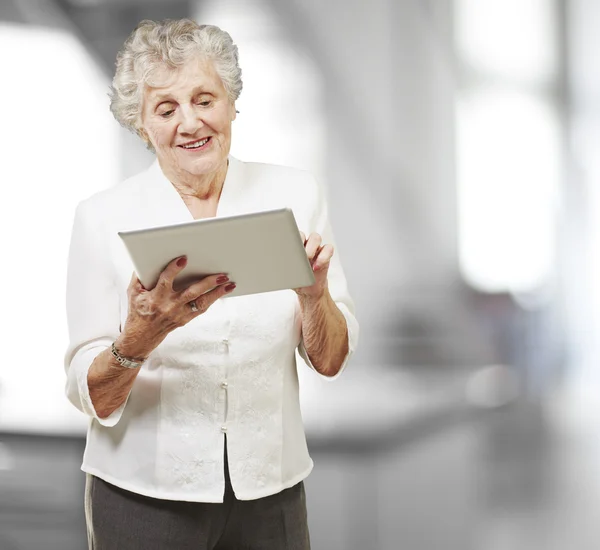 Portret van senior vrouw aanraken digitale tablet, binnen — Stok fotoğraf