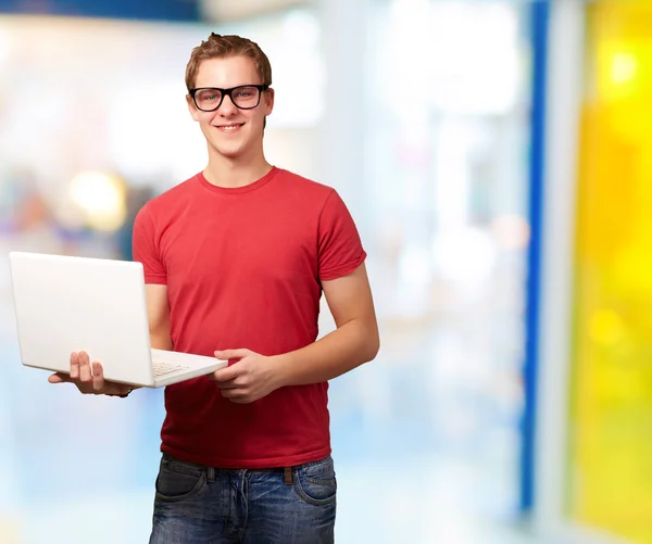 Портрет молодого студента, який тримає ноутбук у класі — стокове фото