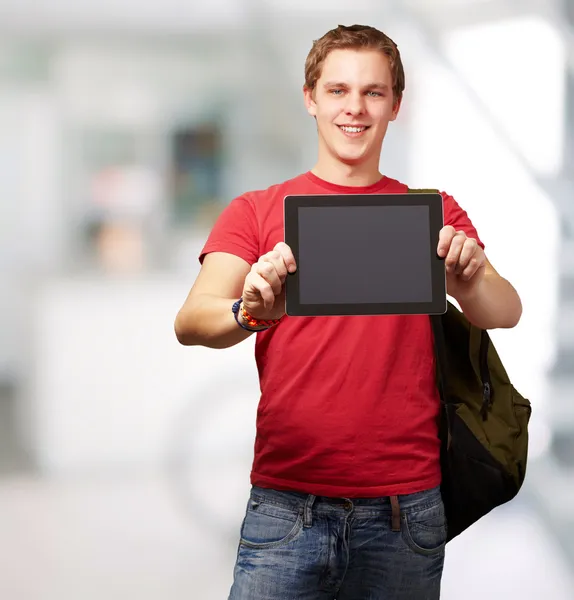 Portrait de jeune homme tenant une tablette numérique à l'intérieur — Photo